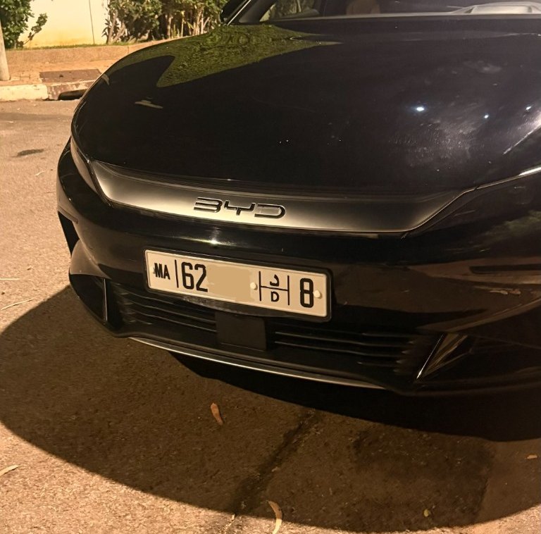 Pose d’une plaque unifiée MA à l’avant d’une berline, le soir