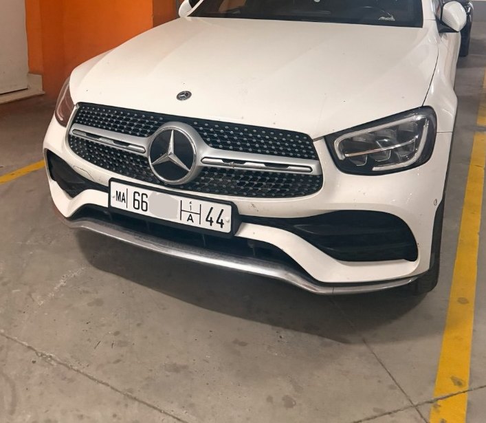 Pose d’une plaque unifiée MA à l’avant d’un SUV, parking