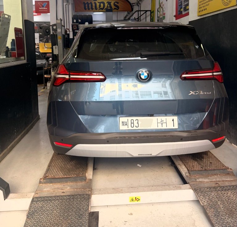 Pose d’une plaque unifiée MA à l’arrière d’un SUV, atelier