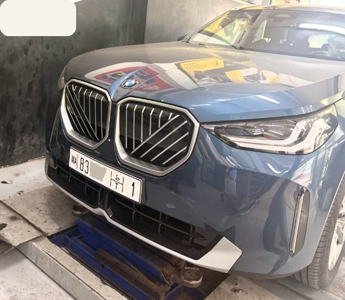 Pose d’une plaque unifiée MA à l’avant d’un SUV, atelier